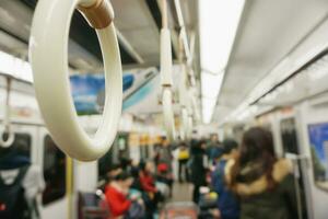 Closeup handle loop in a subway with blurry people background. photo