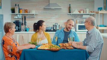 abuelos gasto un relajante familia día. multi generación, cuatro gente, dos contento parejas hablando y comiendo durante un gastrónomo cena, disfrutando hora a hogar. foto