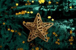 Abstract Christmas background with gold stars on a green velvet background. photo