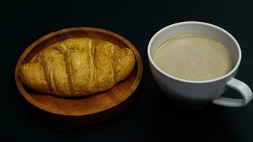 croissant topped with honey with a glass of coffee latte photo