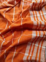 Close-up of orange white checkered napkin or picnic tablecloth texture, Kitchen accessories. photo