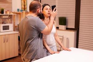 Husband having disagreement with cheating wife showing text from another man in her phone. Frustrated offended irritated accusing woman of infidelity arguing her with messages. photo
