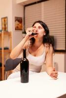 mujer teniendo emocional problema Bebiendo un botella de vino. infeliz persona enfermedad y ansiedad sensación agotado con teniendo alcoholismo problemas. foto