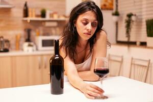 Woman in solitude drinking a lot of alcohol because of depression. Unhappy person disease and anxiety feeling exhausted with having alcoholism problems. photo