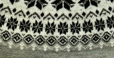 Black and white Winter Knitted Sweater Pattern Design with snowflakes. Handmade knitting wool fabric texture. Background of kniting patterns and ornament. photo