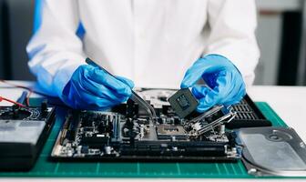 The technician is putting the CPU on the socket of the computer motherboard. electronic engineering electronic repair, electronics measuring and testing, repair photo