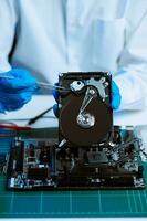 Hard disk drive on the technician's desk and a computer motherboard as a component. the concept of data, hardware, and information technology. photo