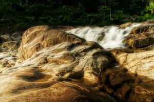 pequeño cascada y Roca con agua movimiento. foto