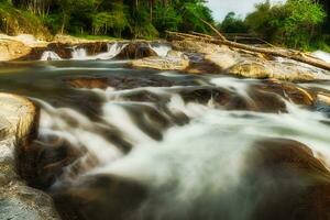 pequeño cascada y Roca con agua movimiento. foto