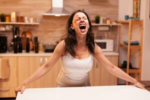 Terrified woman screaming after being brutally beaten by alcoholic husband. Violent aggressive husband abusing injuring terrified helpless, vulnerable, afraid, beaten and panicked wife. photo