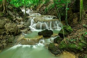 Small waterfall in the forest in summer. photo