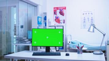 Chroma key on computer in hospital cabinet with medical personnel in the background. Computer with blank and copy space available on display of medicine specialist in clinic cabinet. photo