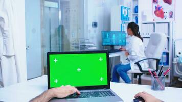 Pov laptop display with green mockup in hospital cabinet. Medical practitioner opening clinic glass door. Medic using notebook with chroma key on display in medical clinic. photo