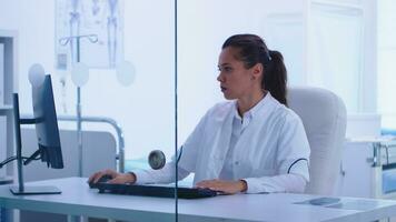 ver mediante vaso pared de médico en gabinete mientras asistente dando médico paciente radiografía. médico examinando paciente radiografía antes de dando un tratamiento a cura su afecto. foto