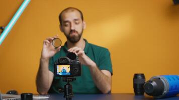 Professional photographer talking about nd filters effect on image for his vlog.Variable ND filter review, camera gear and equipment video. Ceator influencer social media star distributing online content photo
