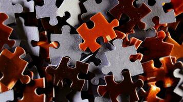 Background of Colored Puzzle Pieces that Rotating Clockwise Top View, CloseUp. Texture of Incomplete Red and Grey Jigsaw Puzzle with Low Key Light Right Rotation video