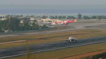 PHUKET, THAILAND - FEBRUARY 23, 2023. Asian low-cost airline Airbus A320-216, HS-BBO of AirAsia taking off at Phuket airport, panoramic view of the airfield. Plane departing, climbing video