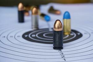 Black 9mm bullets on shooting target paper, soft and selective focus. photo