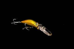 a golden fishing lure on a black background photo
