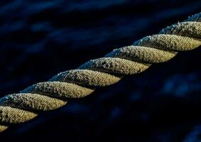 a close up of a rope over blue water photo