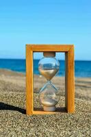 reloj de arena en la playa foto