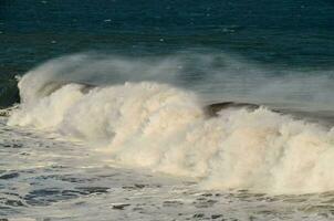 a large wave crashing into the shore photo