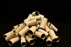 a pile of rolled up toilet paper tubes on a black background photo