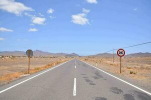 an empty road with two speed limit signs photo