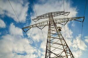 an electricity tower with a blue sky in the background photo