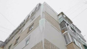 isicles on russian chrushevka 5storey building corner at winter day snowfall video