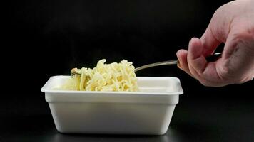 hand med gaffel omröring och kyl- kokta omedelbar spaghetti video
