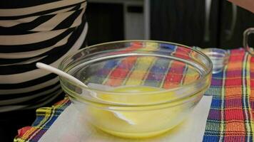 senior caucasian woman adding three chicken eggs to the bowl with sweet dough video