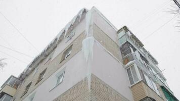 isicles on russian chrushevka 5storey building corner at winter day snowfall video