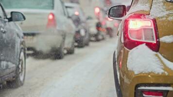 snö täckt bil svans ljus på vinter- dag i trafik under snöfall video