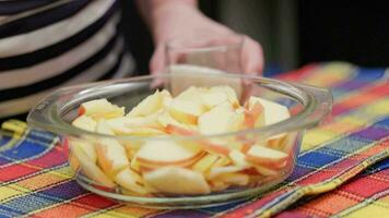 senior woman pouring sugar in glass bowl with chopped apples video