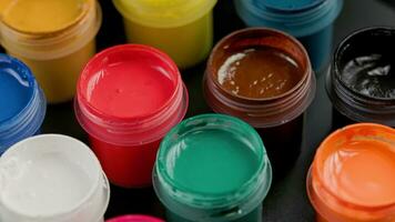 loopable rotating closeup background of opened small gouache paint jars video