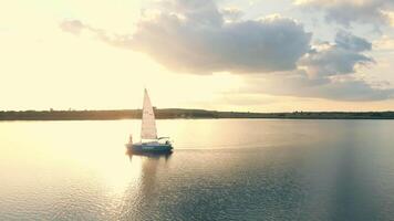 ukraina. lviv. 19.09.2020. ett Yacht i de hav från en fåglar öga se på solnedgång. de himmel är reflekterad i de vatten. flyg på solnedgång nära de Yacht utsikt de segla från en höjd video