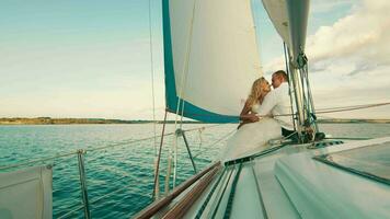 de nygifta är segling på de sjö ombord de Yacht. de njut av varje Övrig, se och leende. rörande varje andras näsor video