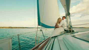 das Jungvermählten sind Segeln auf das See an Bord das Yacht. Sie genießen jeder andere, aussehen und lächeln. berühren jeder Andere Nasen video