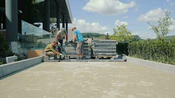 houdende bestrating platen. meester mannen maken een weg van kasseien. video