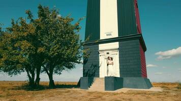 contento Pareja en amor en pie cerca un pequeño edificio en el campo. un acogedor sitio para dos gente. soleado brillante día y dos amantes juntos. video