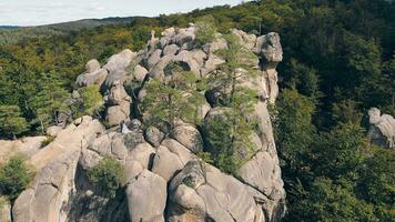 nozze coppia nel montagna roccia a partire dal drone. aereo Visualizza contento Novelli sposi nel amore abbracciare in piedi su superiore di il montagna. video