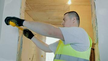 Measurement with measuring tape is being performed by a man when he is repairing an apartment wall. video