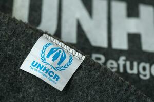 Kyiv, ucrania - 4 de mayo de 2022 acnur el logotipo de la agencia de refugiados de la onu en mantas grises humanitarias foto