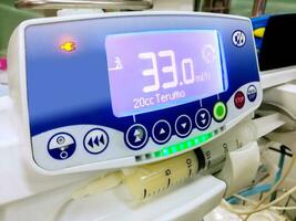 Syringe pump machine with monitor display show the number of the medicine syringe pump pressure in hospital. photo