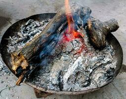 Logs burn in the campfire. Close-up of firewood, coals photo