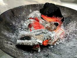 Logs burn in the campfire. Close-up of firewood, coals photo