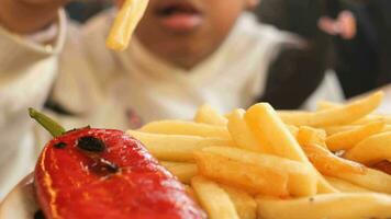 niño comiendo francés papas fritas cerca arriba video