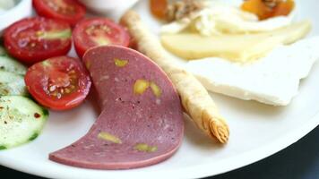 salami sausage cut into thin pieces. tomato and cheese on a plate video