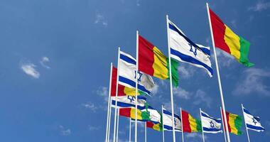 guinea och Israel flaggor vinka tillsammans i de himmel, sömlös slinga i vind, Plats på vänster sida för design eller information, 3d tolkning video